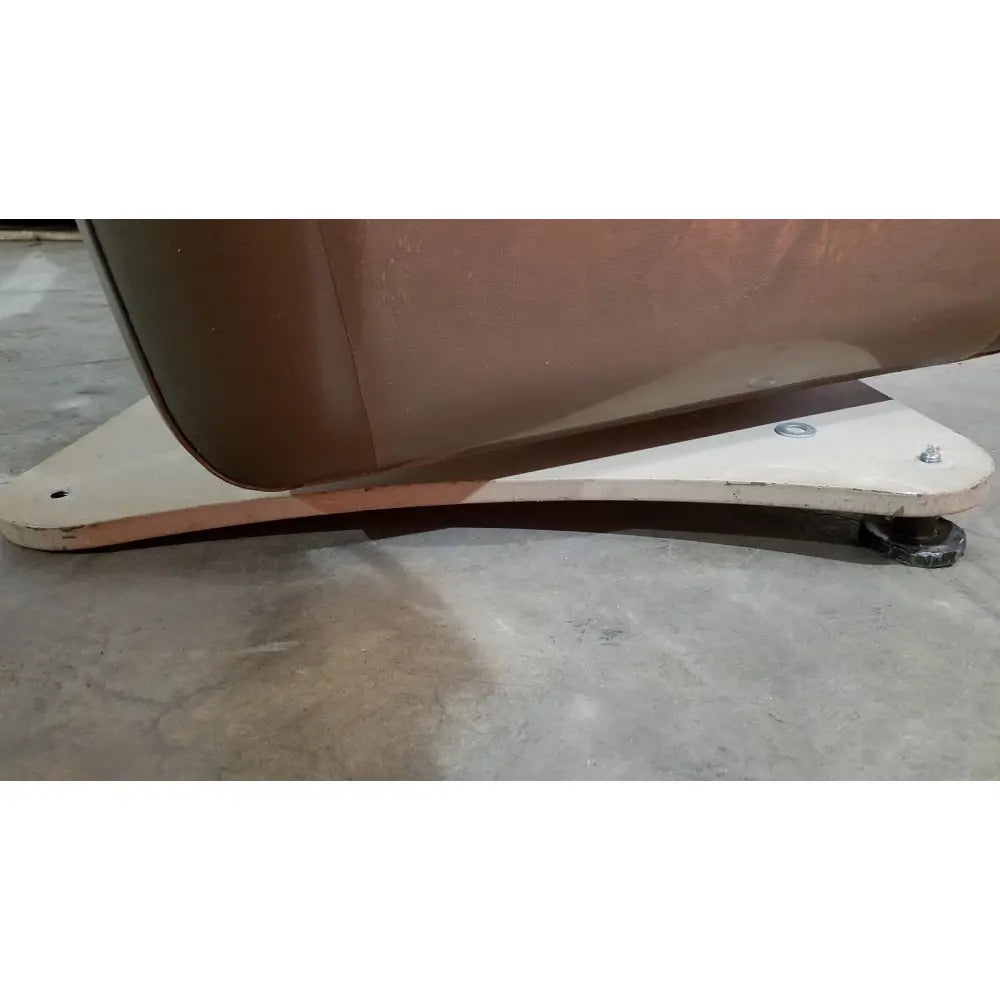 Brown leatherette base of mti programmable podiatry chair with white metal footrest and black caster wheel