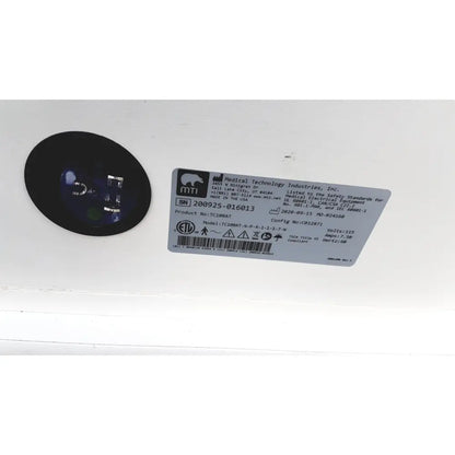 Black circular component with blue-tinted lens from mtt medical technology industries treatment cabinet tc100at