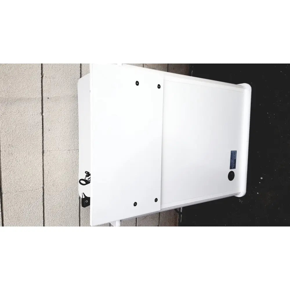 White rectangular outdoor treatment cabinet tc100at with black mounting hardware and a small blue label on right side