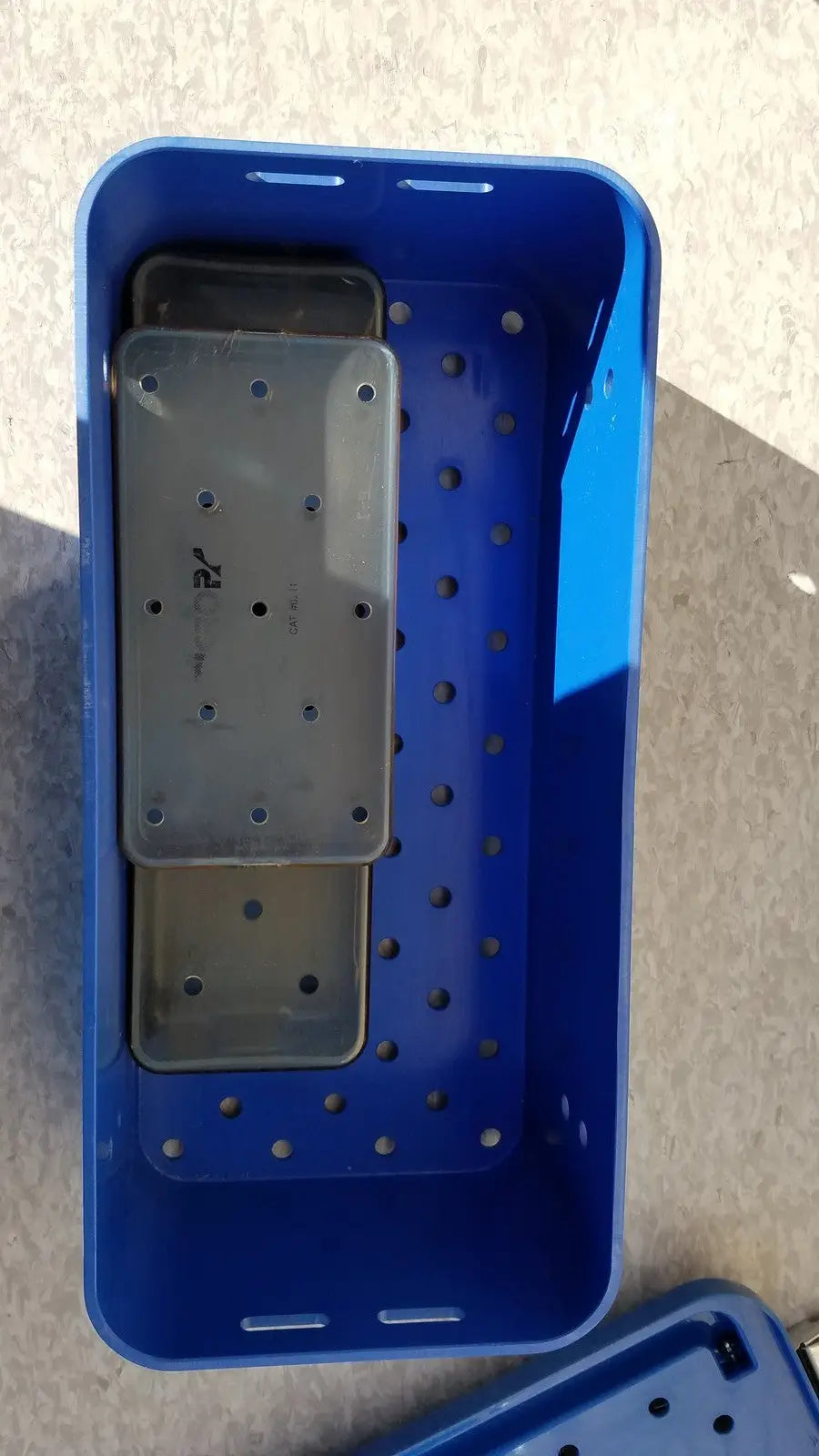 Blue plastic multipak 5006-02-000p sterilization tray with perforated sides and gray rectangular internal tray