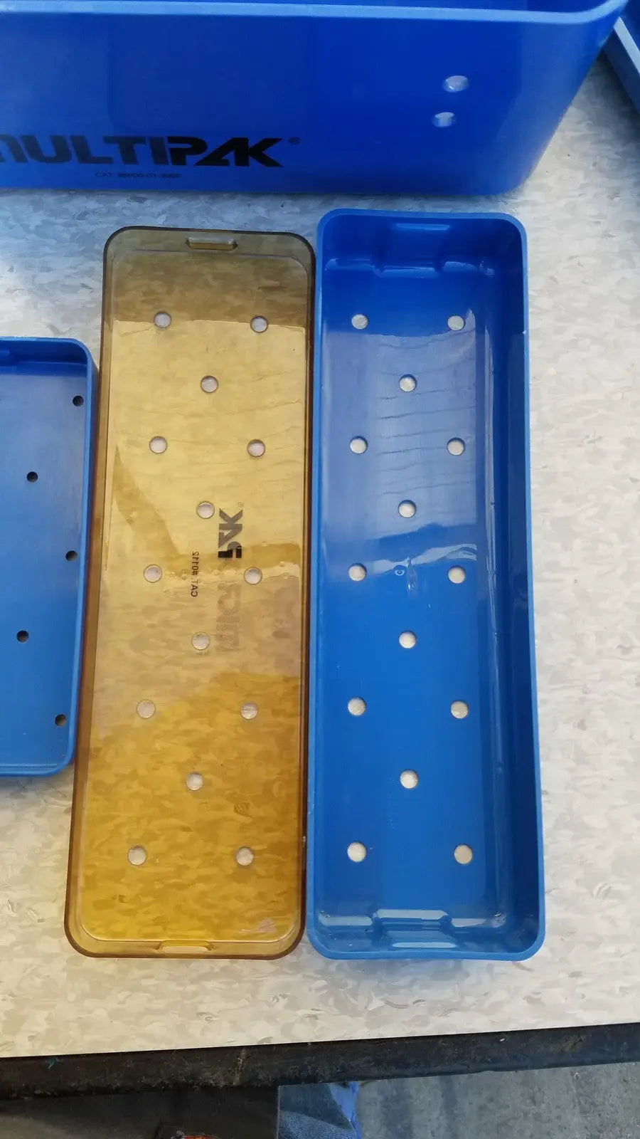 Blue and gold multipak 5006-02-000p plastic sterilization tray with evenly spaced circular holes for medical use