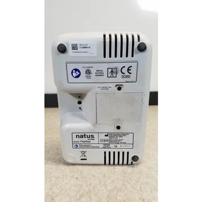 White plastic natus neurology freedop xld004 medical electronic device with ventilation slits and regulatory labels back view