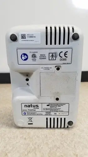 White plastic natus neurology freedop xld004 medical electronic device with ventilation slits and regulatory labels back view