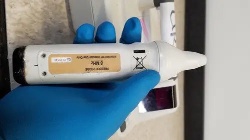 White plastic ear thermometer with black tip and beige 8 mhz label from natus neurology freedop xld004 model