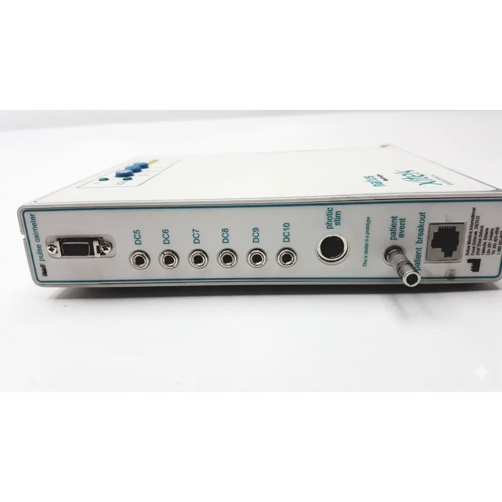 White rectangular natus neurology xltek brain monitor with multiple ports labeled connectors and a small blue button on top left