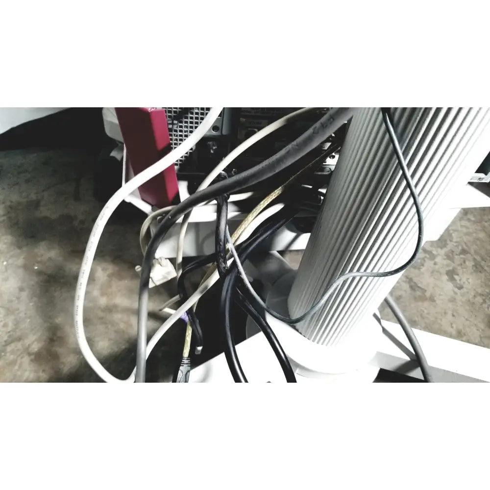 Tangled black and white cables at the back of nec laborie aquarius ct urodynamic analyzer with red power strip visible
