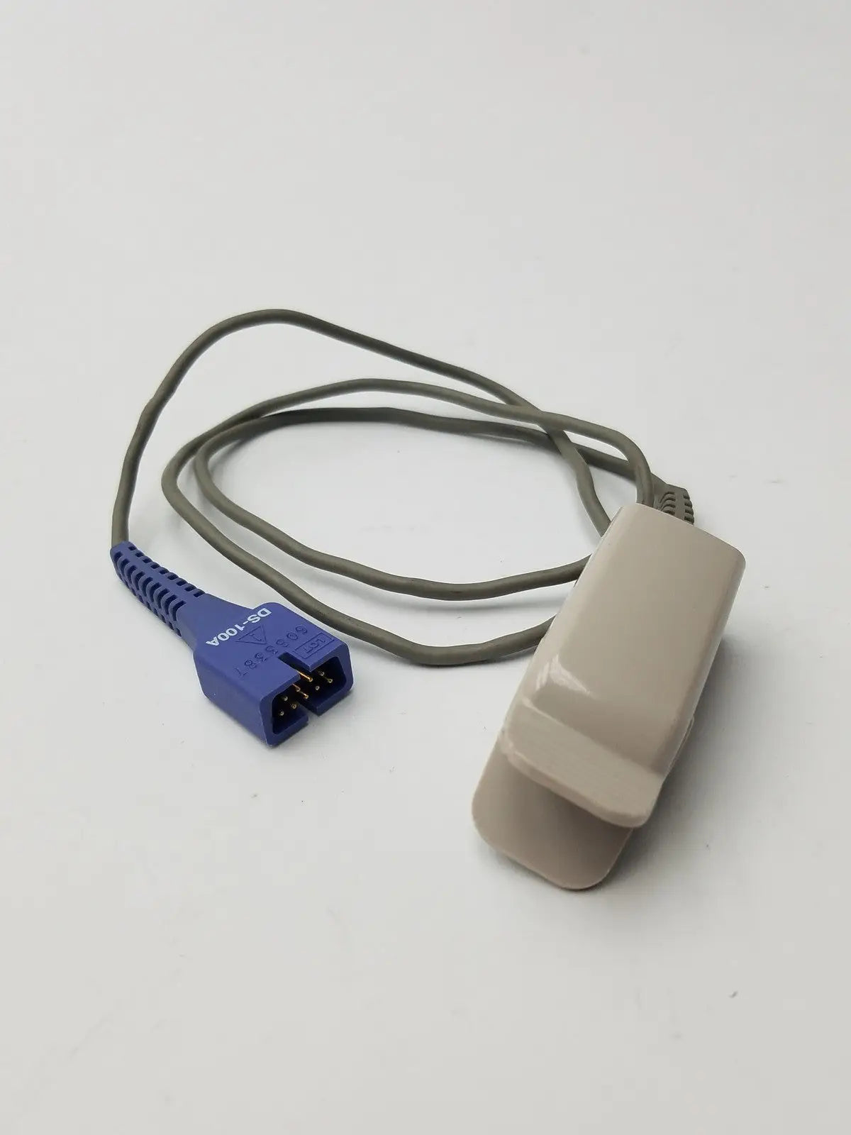 Beige plastic nellcor compatible direct connect spo2 sensor with gray cable and blue connector for adult clip use