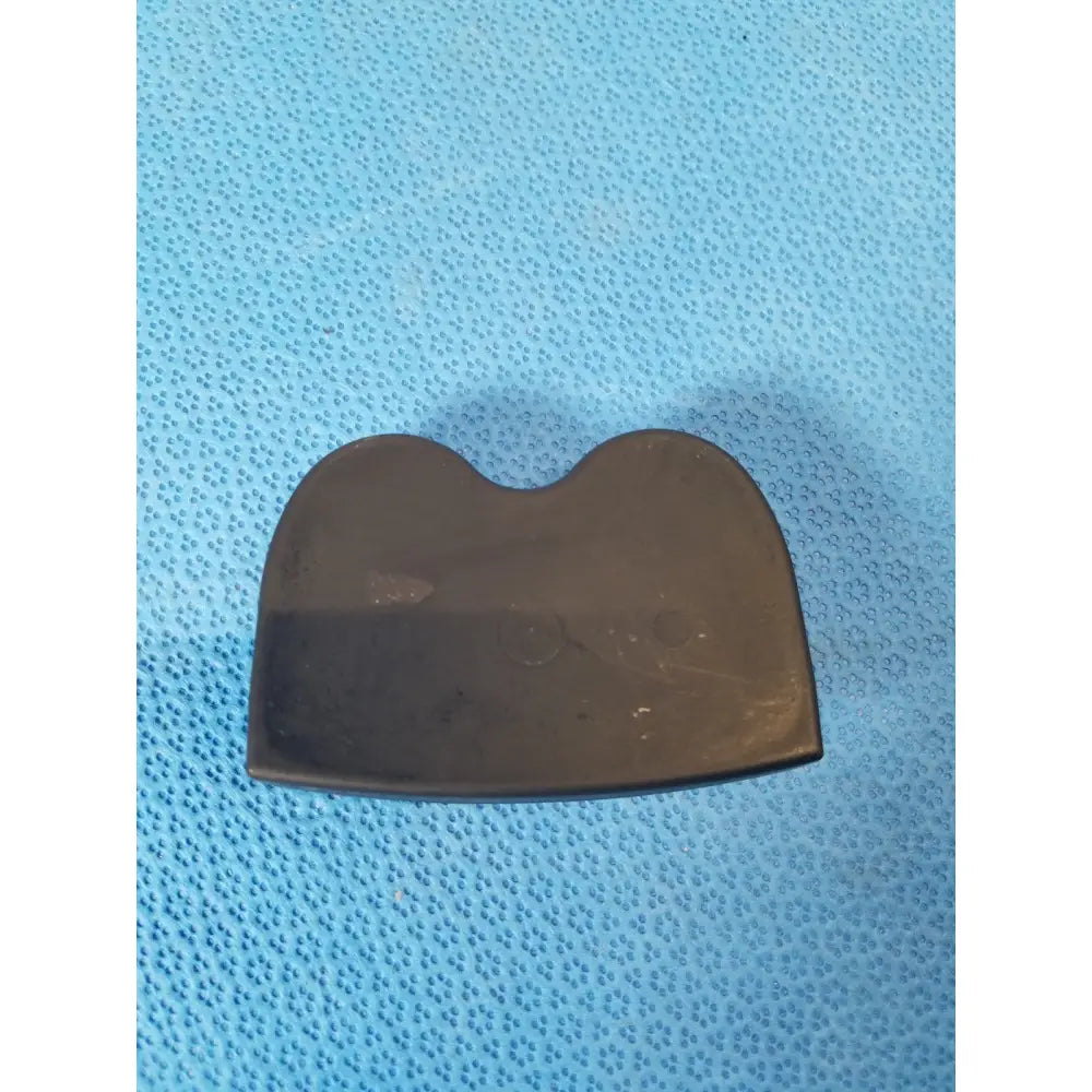 Dark brown smooth rubber spatula with rounded top and curved edges paired with nellcor puritan bennett portable pulse oximeter case