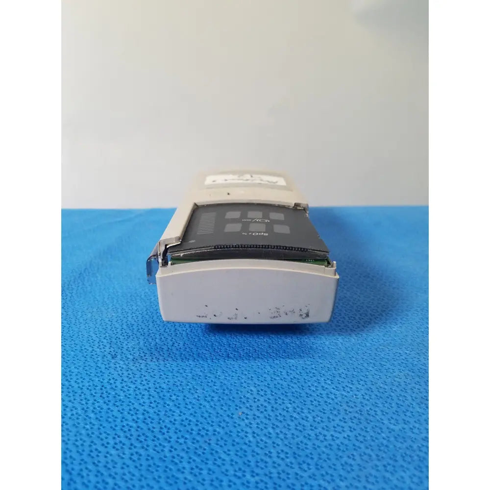 Beige plastic nellcor puritan bennett n-20 portable pulse oximeter showing black internal circuit board and components