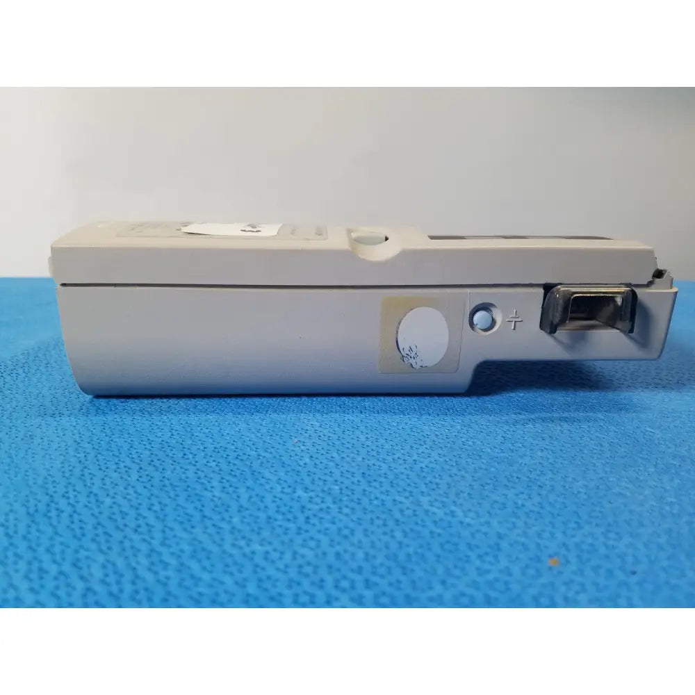 Beige plastic nellcor puritan bennett portable pulse oximeter with circular button plus sign indicator and metallic port