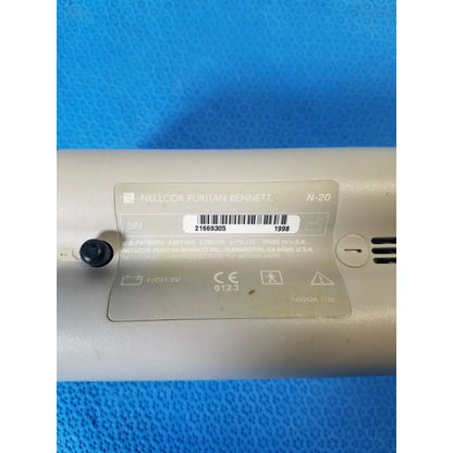 Beige nellcor puritan bennett n-20 portable pulse oximeter with metallic label and black power button in case