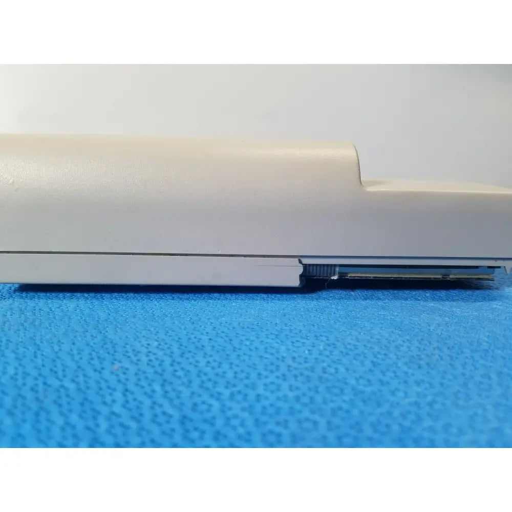Cream-colored plastic laptop hinge with metallic connector visible beneath casing of nellcor puritan bennett portable pulse oximeter case