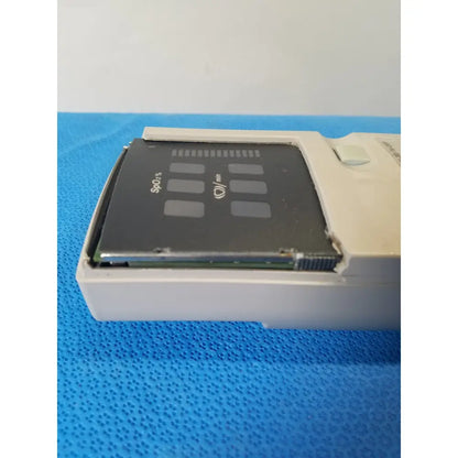 A white plastic nellcor puritan bennett n-20 portable pulse oximeter housing a black spo2 sensor with gray markings and oxygen icon