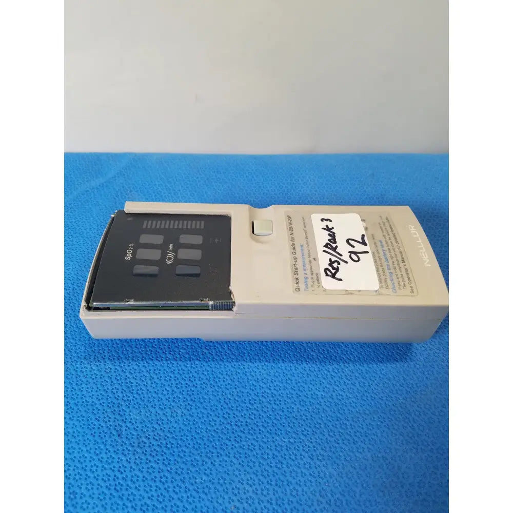 Beige nellcor puritan bennett n-20 portable pulse oximeter with black sensor panel and white label in carrying case