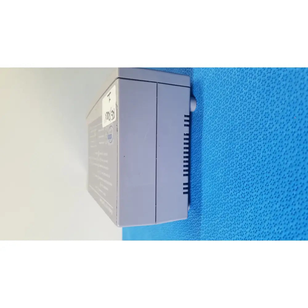 Gray plastic industrial control box with label and ventilation slits on the back of the nellcor puritan bennett oximax pulse oximeter spo2