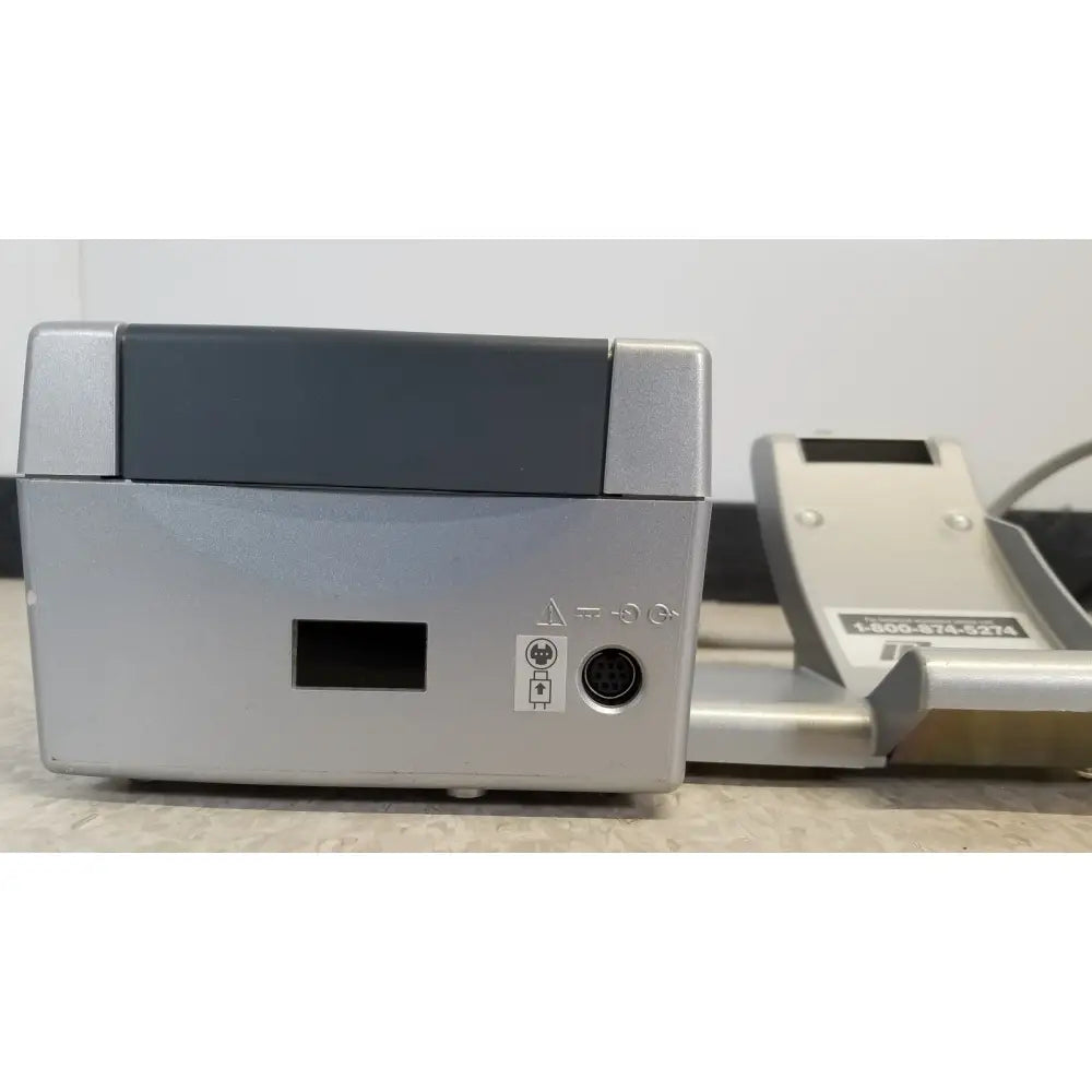 Back side of silver nidek ar-20st1 handheld autorefractor printer with dark gray top panel and circular port