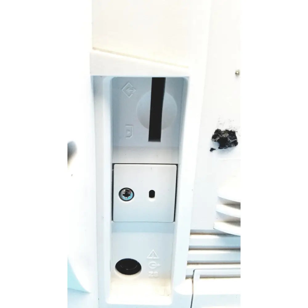White plastic electrical outlet with circular screw cover and slot on the back of Nihon Kohden life scope bedside monitor