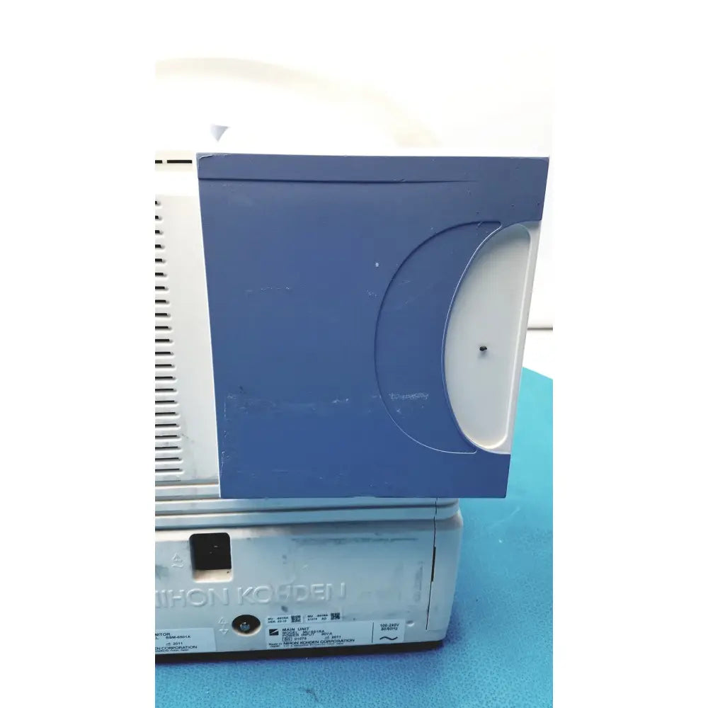 Blue plastic cd player with white circular slot and ventilation grille on the side of nihon kohden life scope bedside monitor