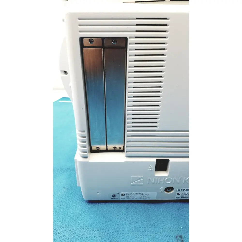 White plastic nihon kohden lifescope bedside patient monitor showing the back with two vertical metallic battery compartments