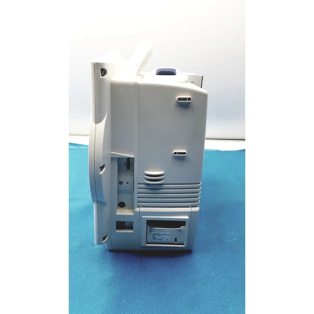 Gray plastic nihon kohden lifescope bedside patient monitor with blue circular knob and ventilation slits on side