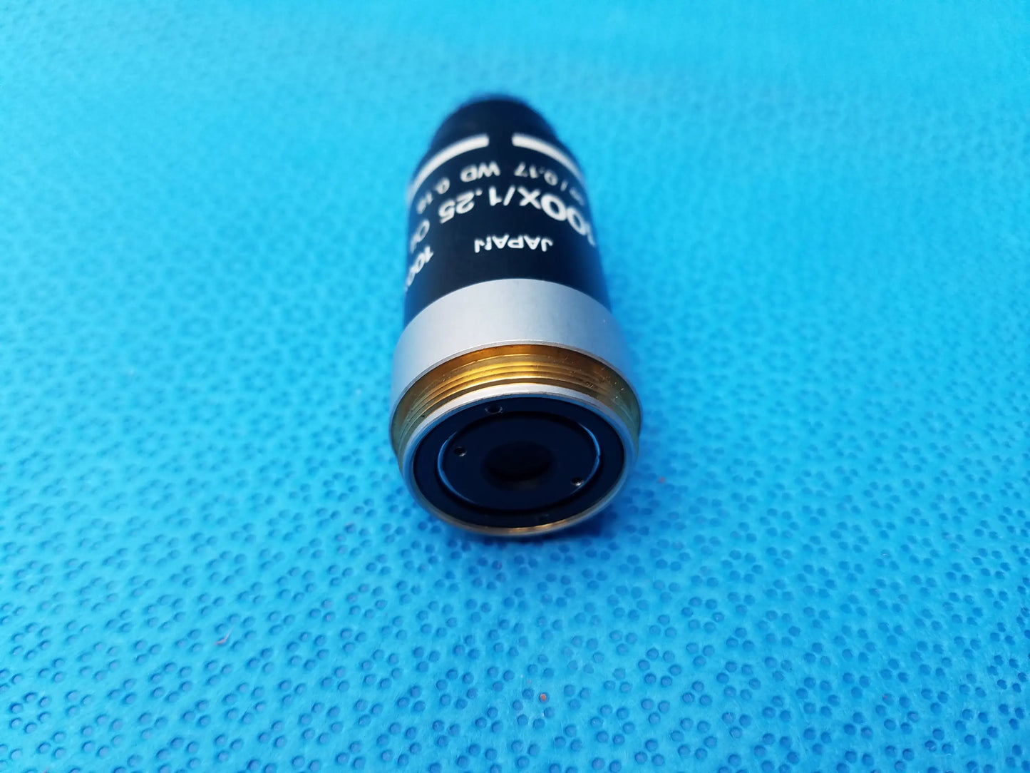 Black and silver microscope objective lens with gold threading marked japan 10x 0.25 numerical aperture compatible nikon microscope