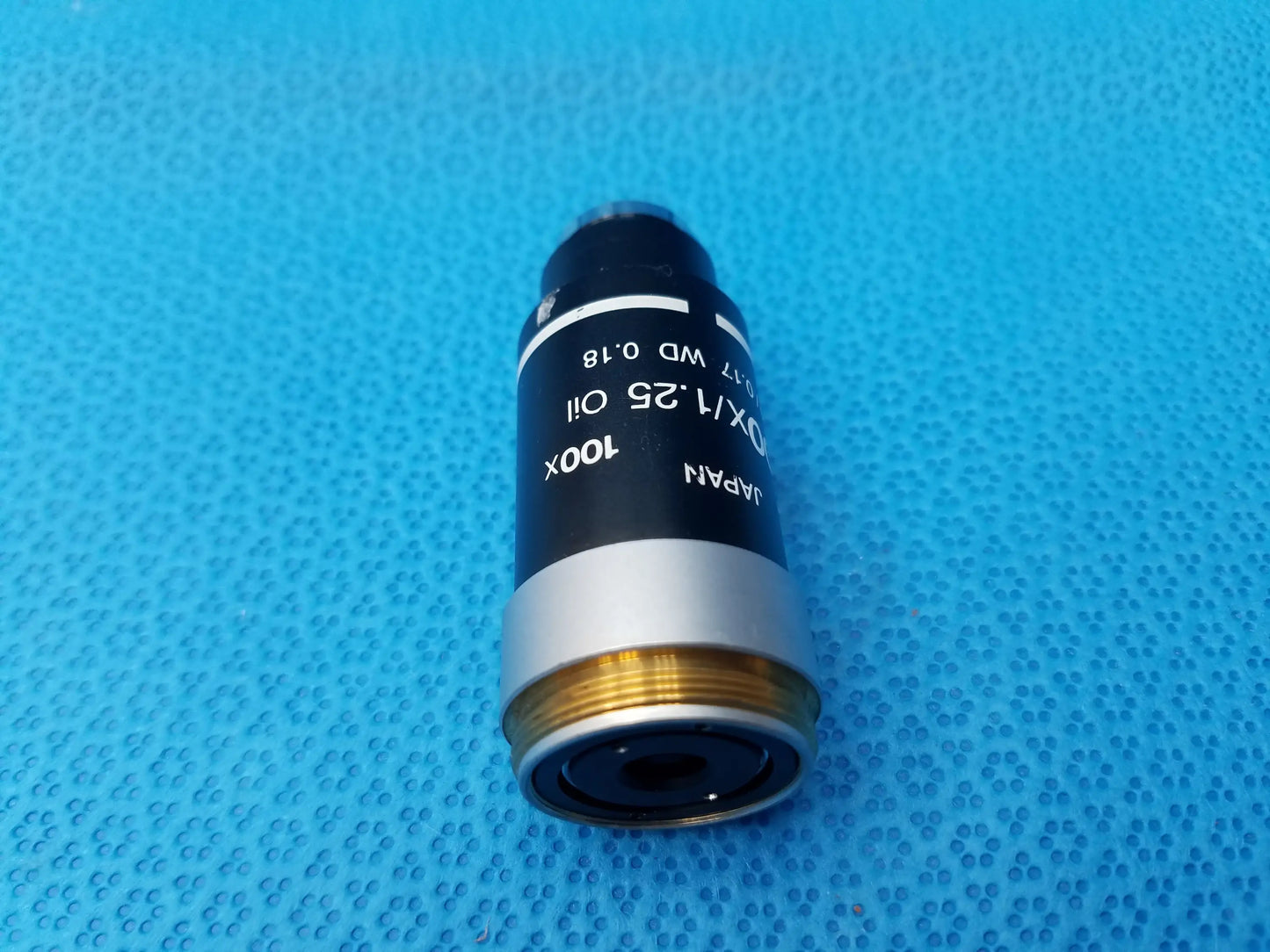 Black and silver Nikon 100x oil microscope objective with gold threading, numerical aperture 1.25, compatible Nikon microscope