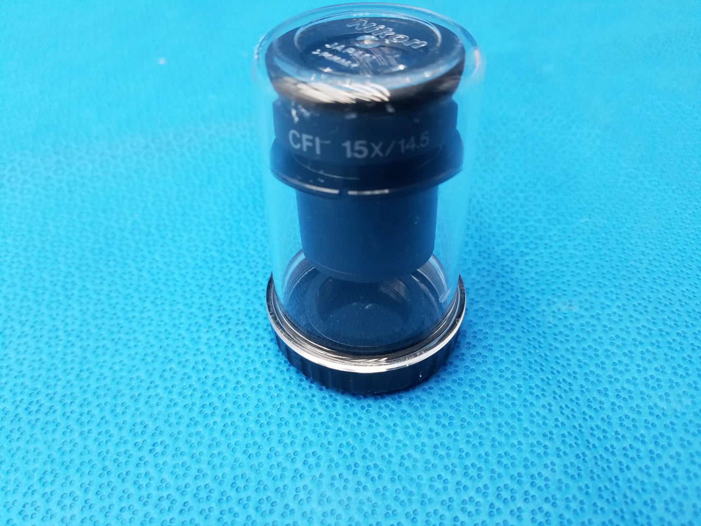 Black and silver nikon cfi 15x microscope eyepiece with field number 14.5 in clear protective storage case
