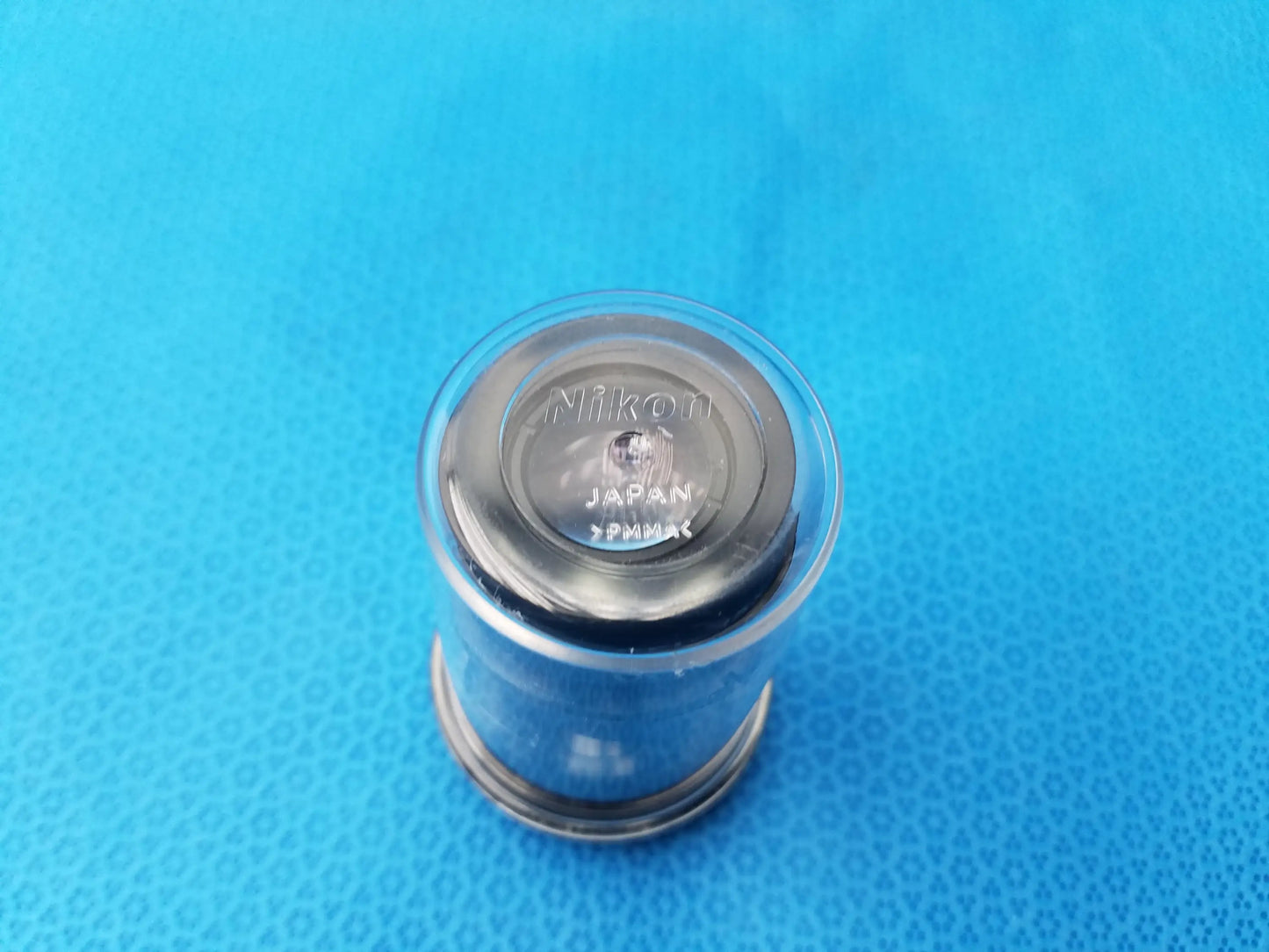 Image of the back side of a black nikon japan pm10x camera lens cap for nikon cfi 15x microscope eyepiece with field number storage case
