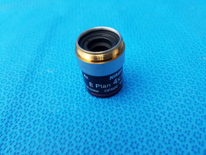 Nikon e plan 4x microscope objective lens with numerical aperture 0.10, metallic gold rim, and black body for microscopy