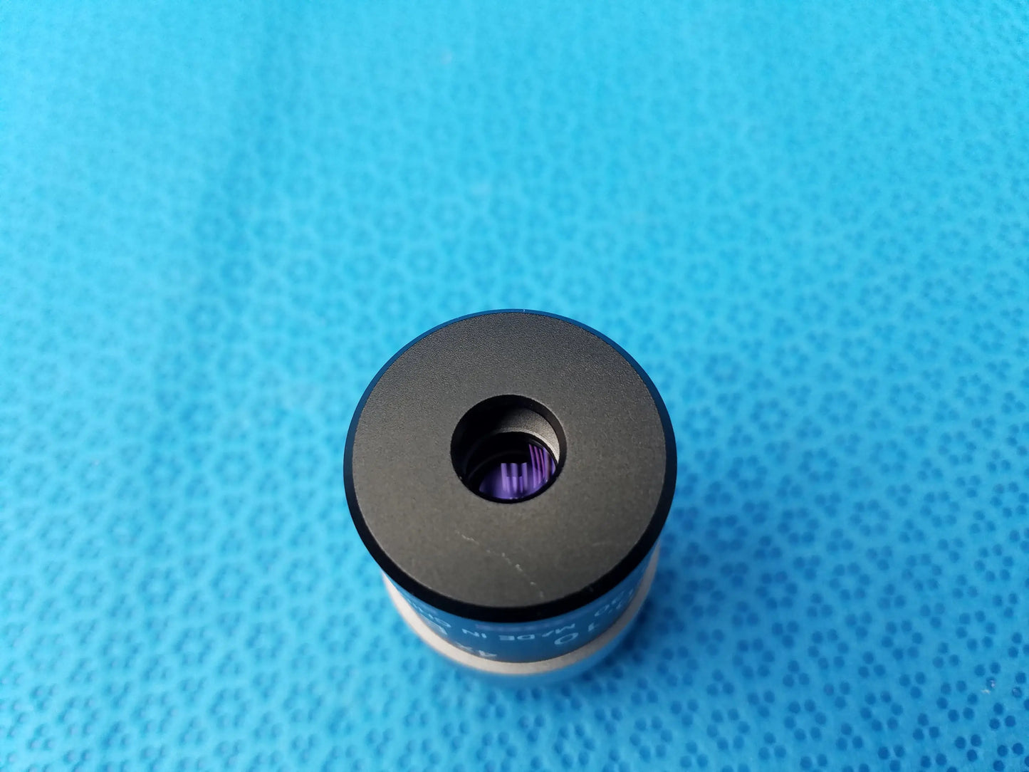 Black cylindrical nikon e plan microscope objective with purple internal element and blue numerical aperture labeling