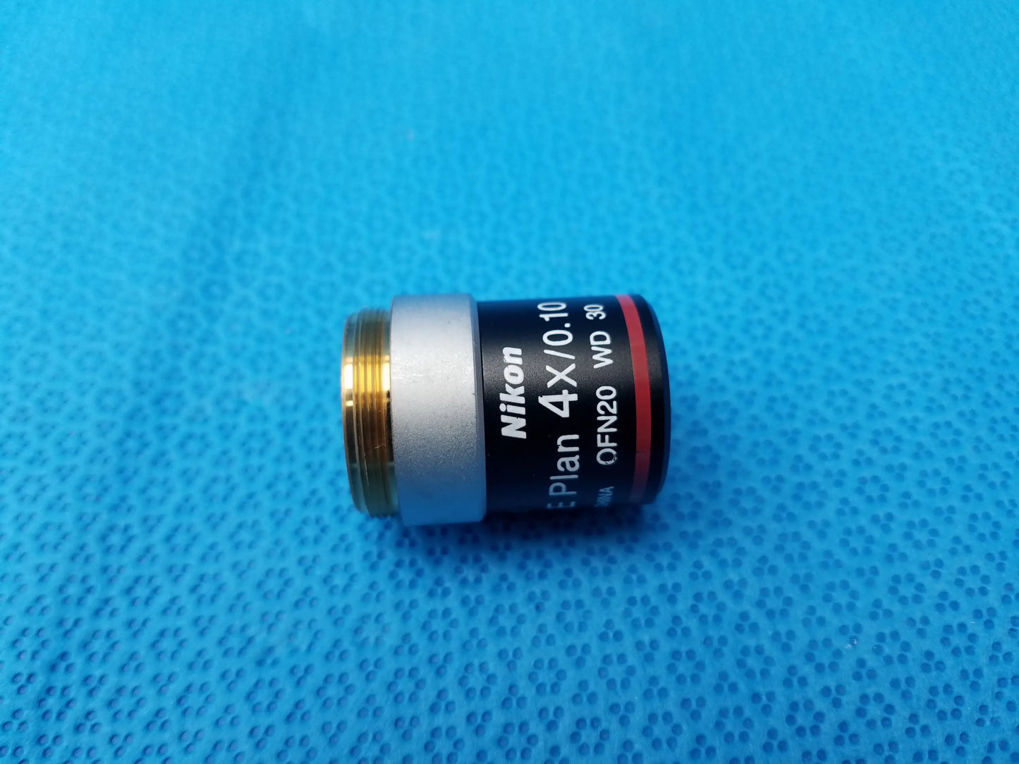 Nikon E Plan 4x microscope objective with silver and black body, gold threaded mount, numerical aperture 0.10