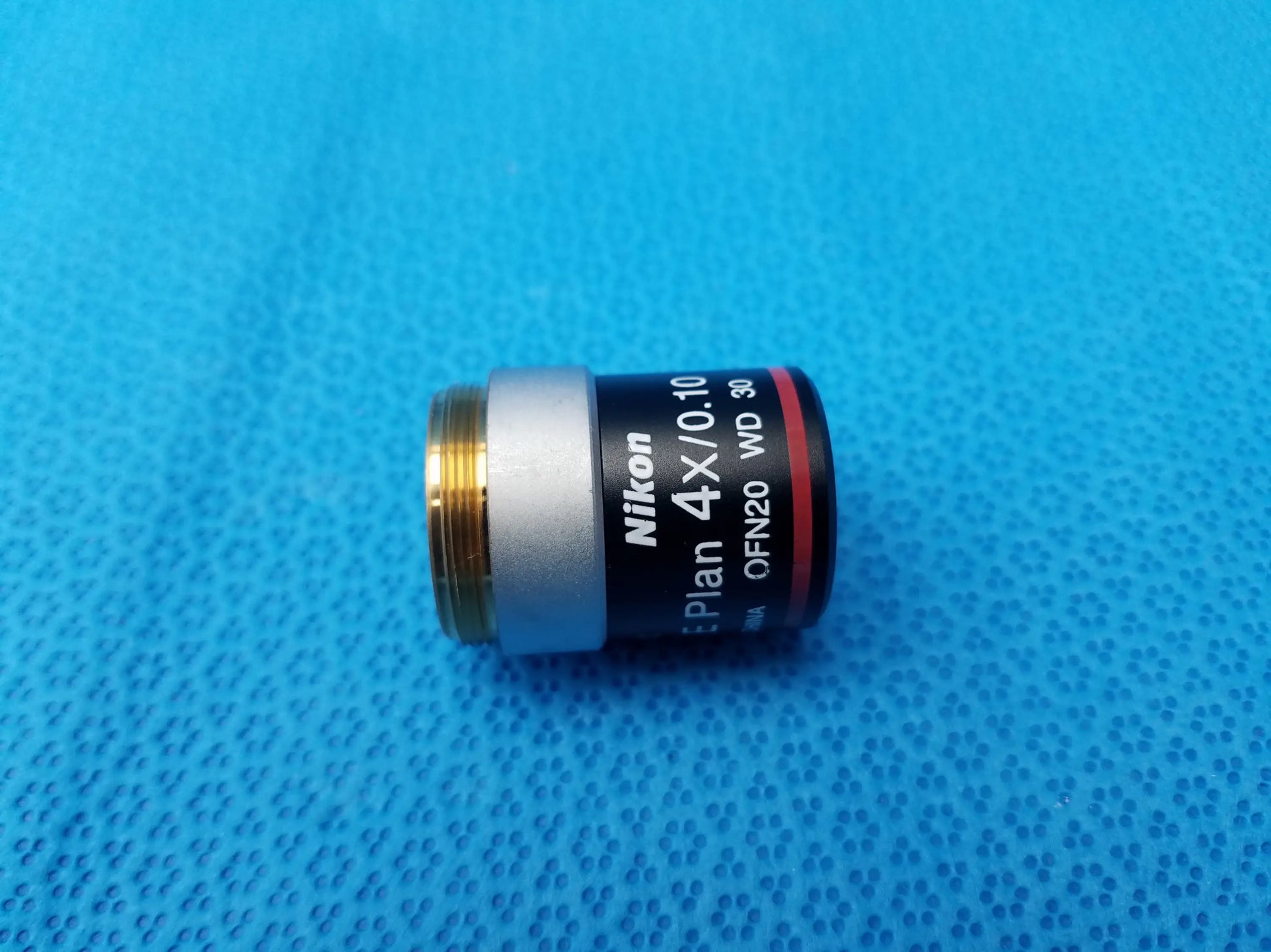 Nikon E Plan 4x microscope objective with silver and black body, gold threaded mount, numerical aperture 0.10