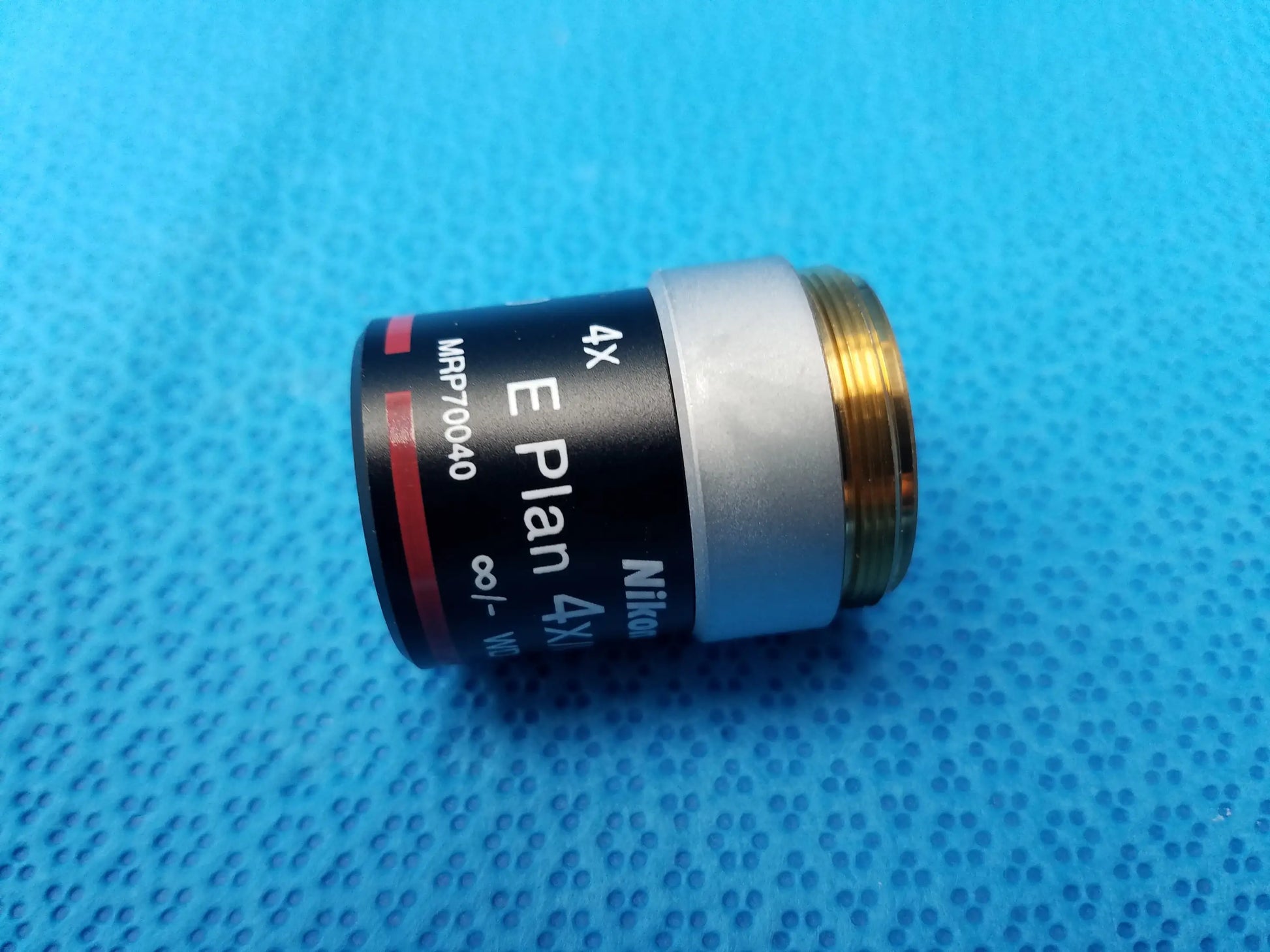 Nikon e plan 4x microscope objective with numerical aperture 0.10 features black silver body and gold threaded mount