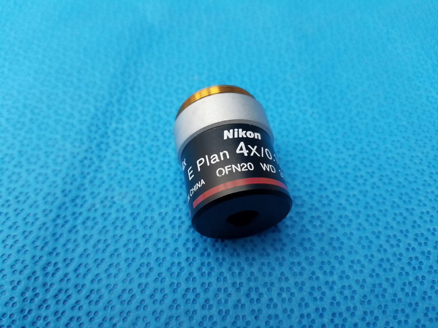 Nikon e plan 4x microscope objective with numerical aperture 0.10 features a silver metal body and gold threaded top
