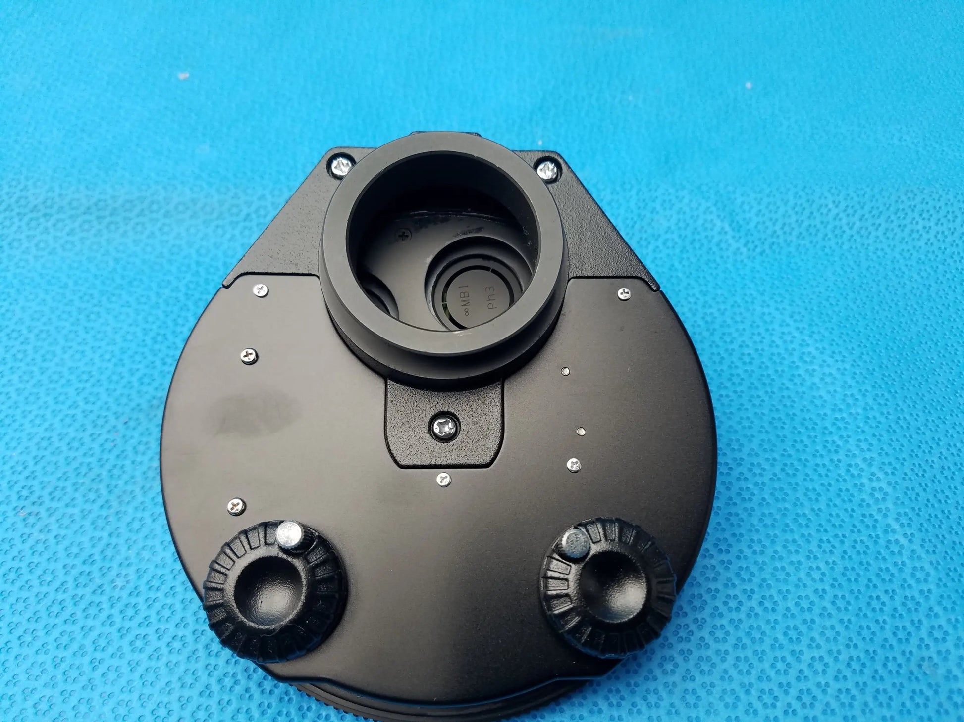 Black plastic nikon microscope condenser stage with two adjustment knobs and central hole for phase contrast turret use