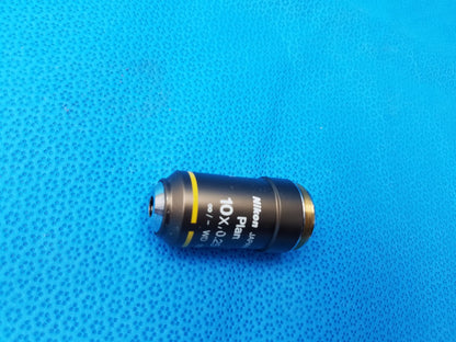 Black Nikon Plan 10x/0.25 microscope objective lens with gold threaded mount and yellow stripe for compatible Nikon microscope systems