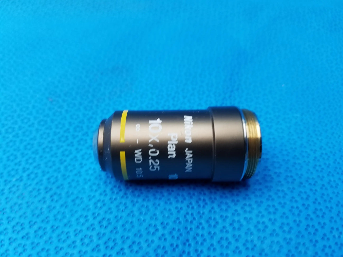 Black nikon plan 10x 025 microscope objective lens with gold threading and yellow band for compatible nikon microscope systems