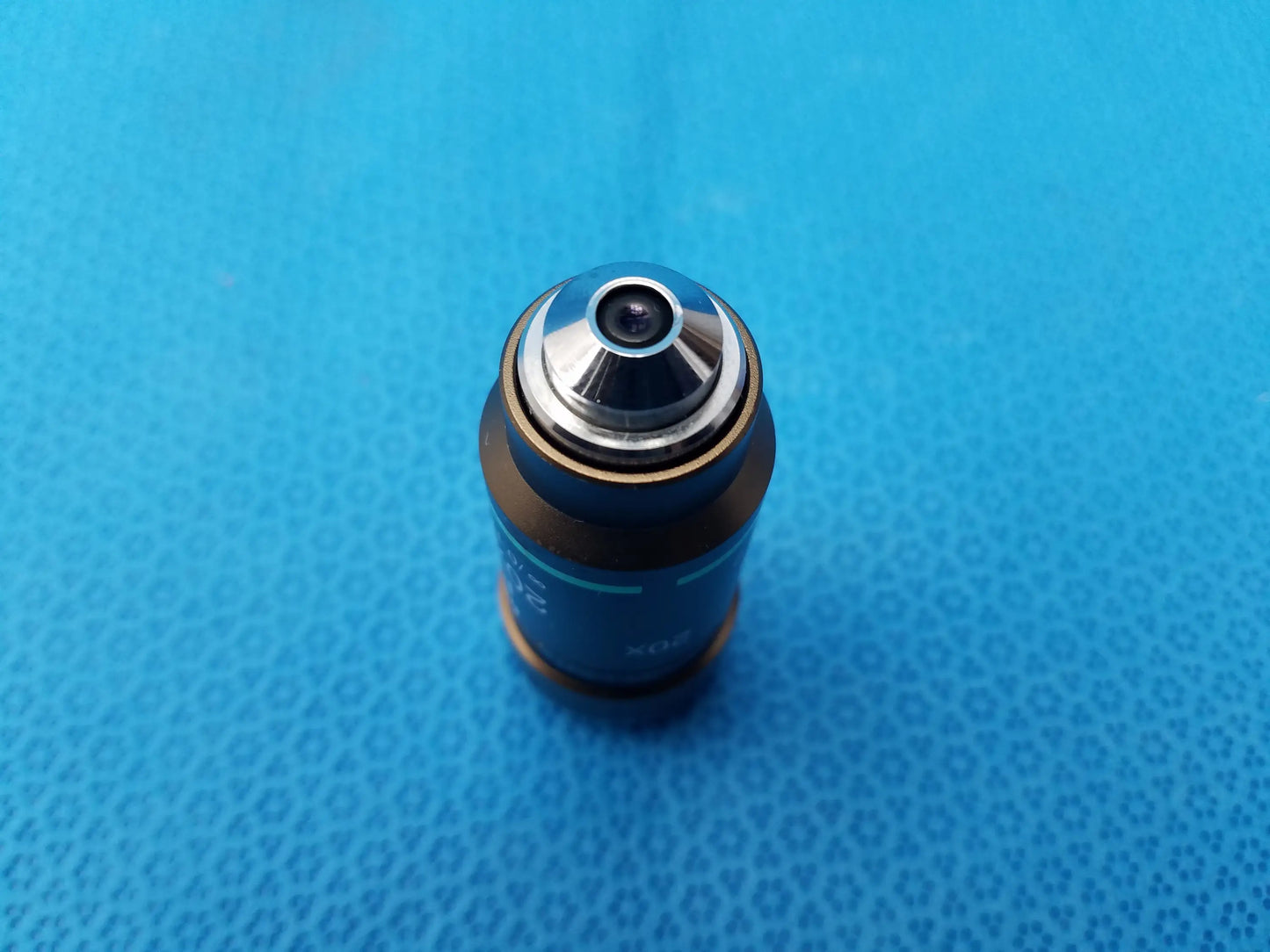 Nikon plan 20x/0.40 infinity corrected microscope objective lens with blue cylindrical body, silver top, and gold ring