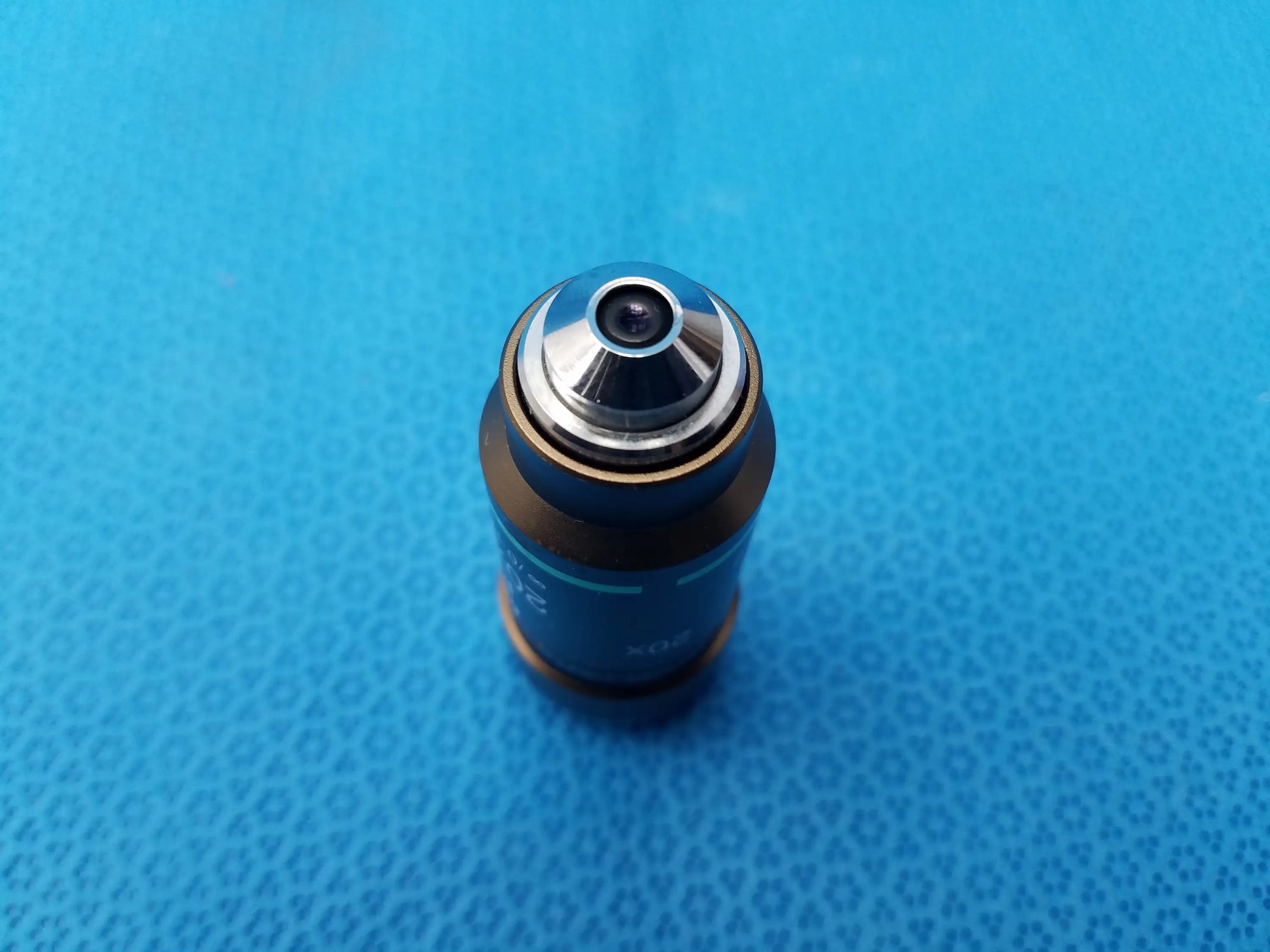 Nikon plan 20x/0.40 infinity corrected microscope objective lens with blue cylindrical body, silver top, and gold ring