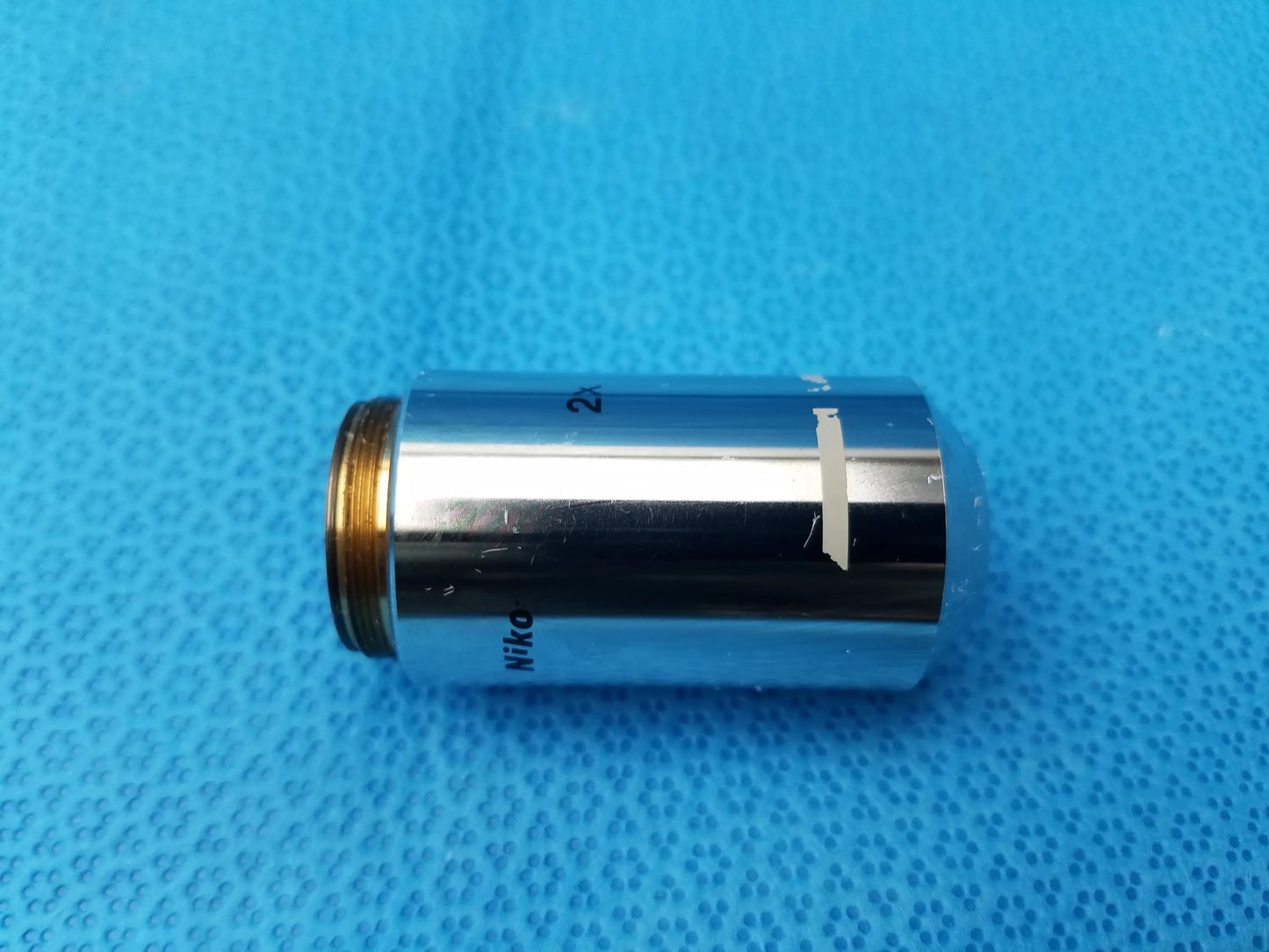 Silver Nikon Plan 2x microscope objective lens with gold threaded mount for compatible Nikon microscope systems