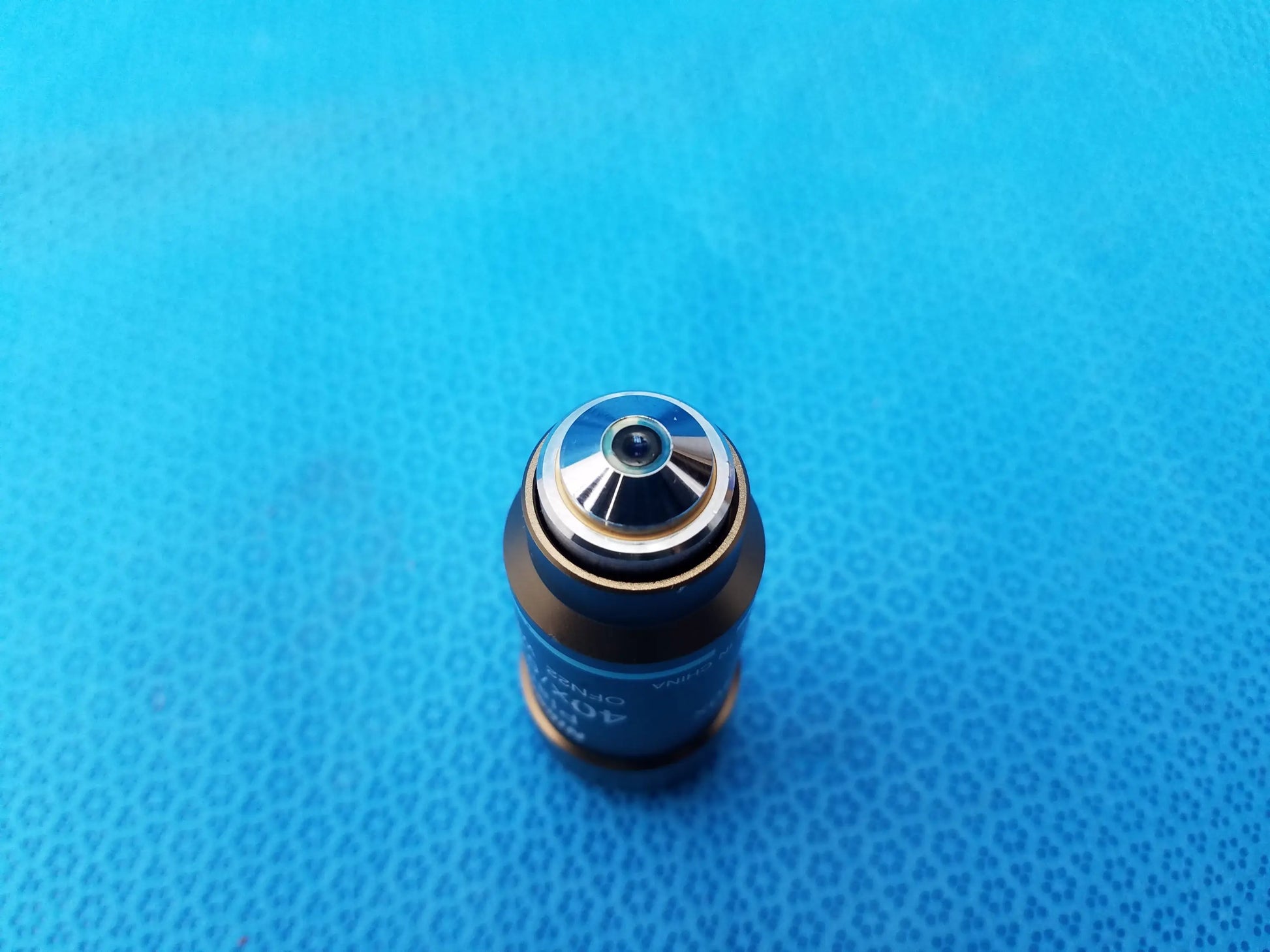 Blue cylindrical microscope objective with metallic silver top and engraved markings for nikon microscope systems