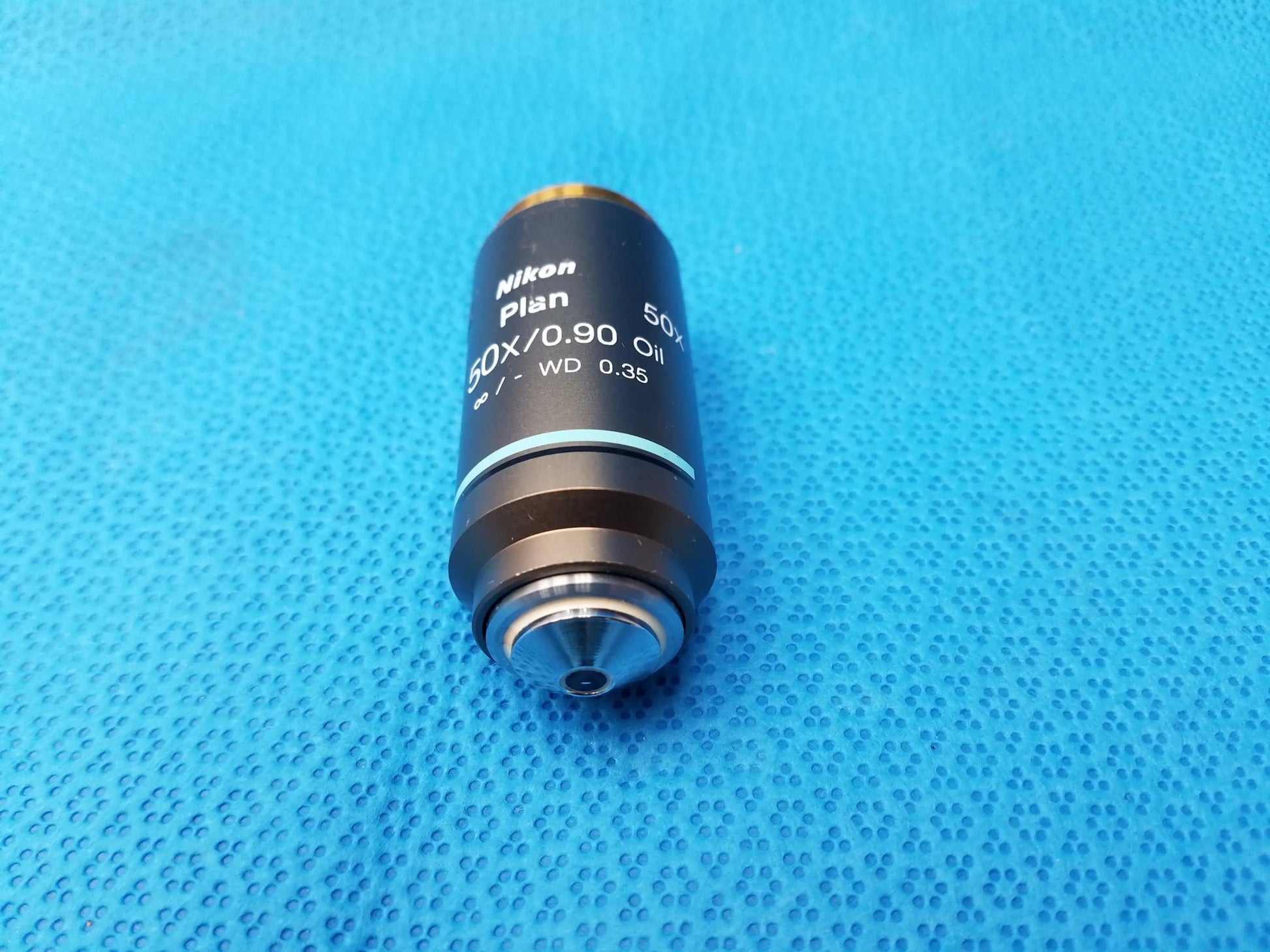Nikon plan 50x/0.90 oil microscope objective with black body and silver threading for compatible Nikon high-magnification use