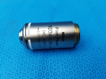 Nikon plan fluor 100x microscope objective with silver metallic body and gold threaded mount compatible Nikon use
