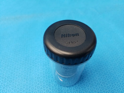 Black nikon lens cap with textured grip and clear plastic body compatible with plan fluor microscope objective mrh01902