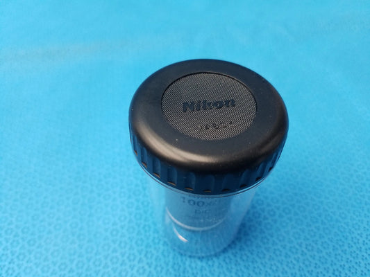 Black nikon lens cap with textured grip and clear plastic body compatible with plan fluor microscope objective mrh01902