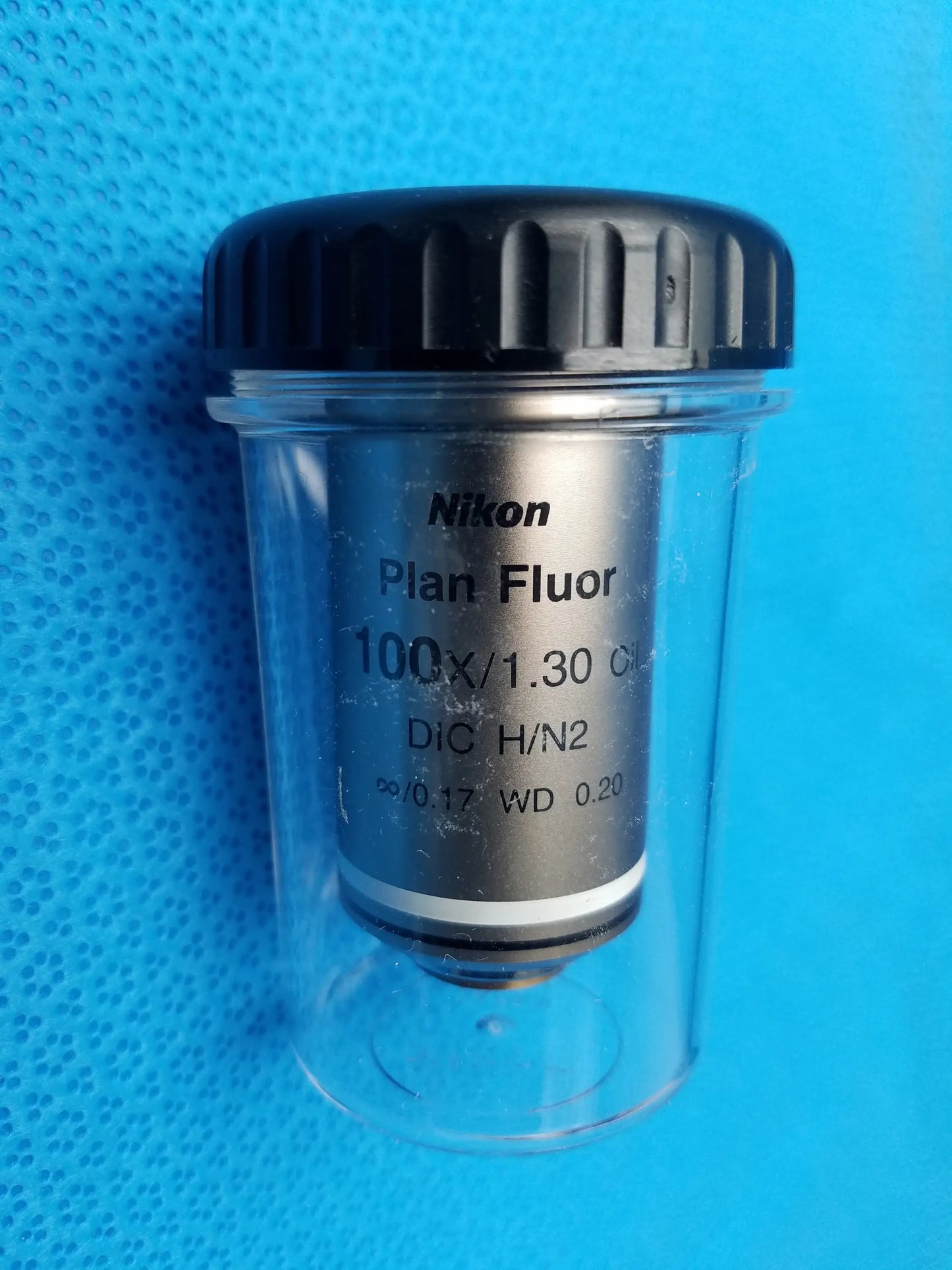 Nikon plan fluor 100x 1.30 microscope objective lens in clear protective case with black ribbed cap compatible Nikon