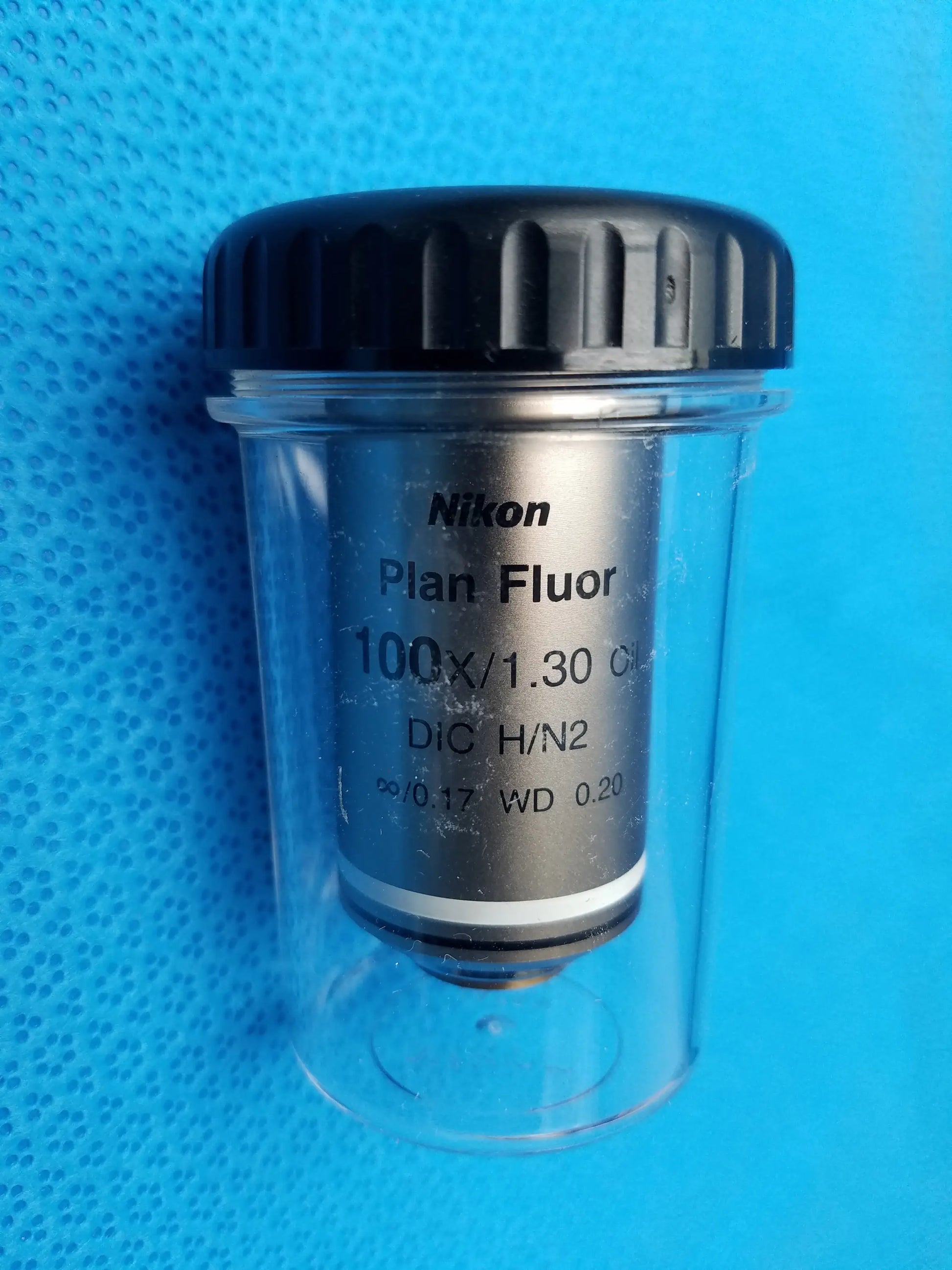 Nikon plan fluor 100x 1.30 microscope objective lens in clear protective case with black ribbed cap compatible Nikon
