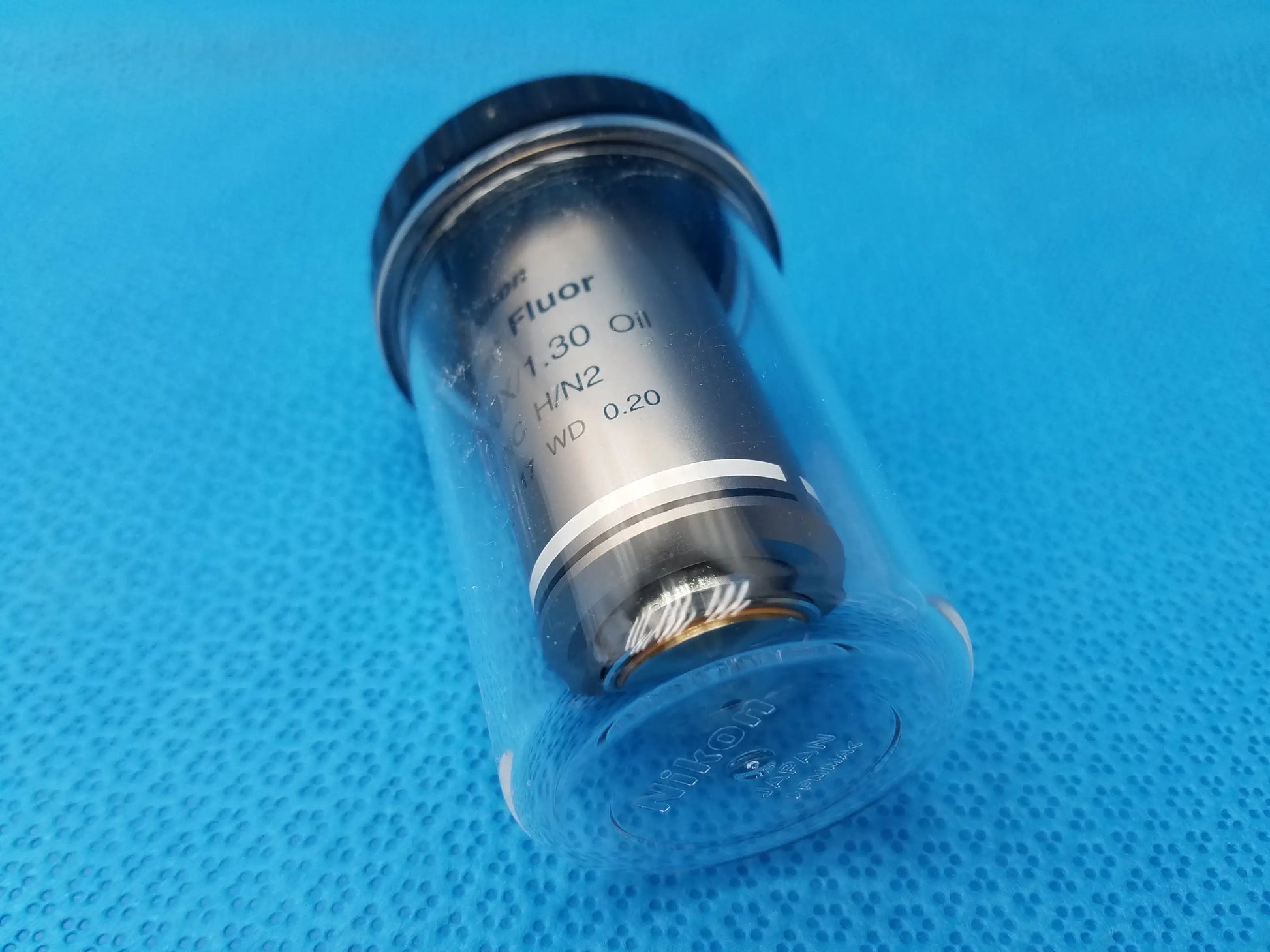 Black and silver Nikon plan fluor 100X oil immersion microscope objective with clear protective casing compatible Nikon models