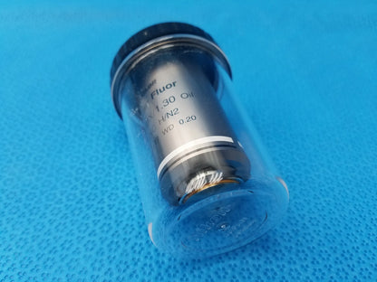 Black and silver Nikon plan fluor 100X oil immersion microscope objective with clear protective casing compatible Nikon models