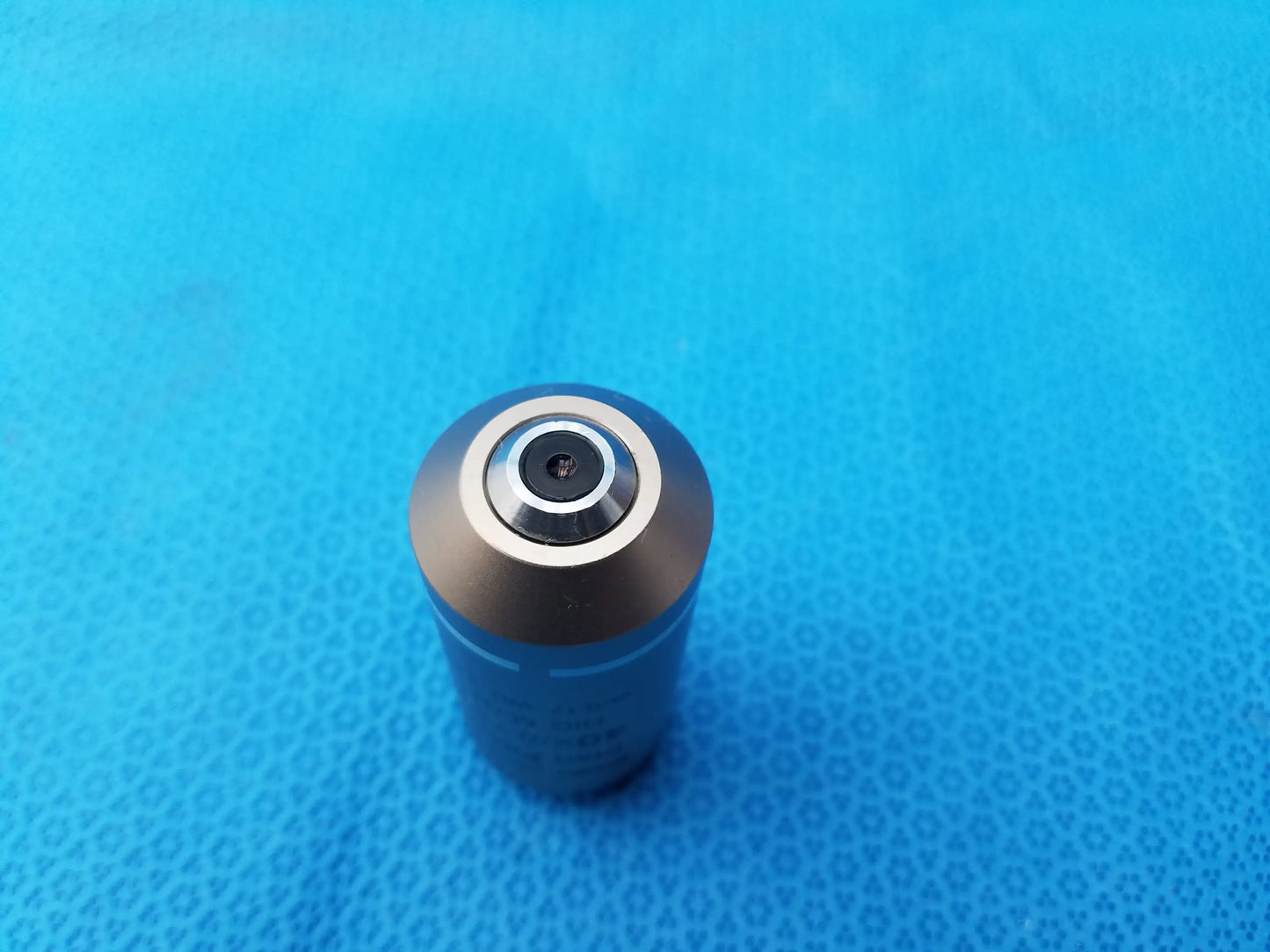 A sleek metallic plan fluor microscope objective with a polished silver top ring compatible with Nikon microscopes